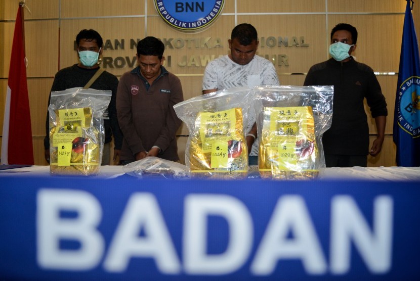 Tersangka dengan barang bukti narkotika jenis sabu ditunjukkan saat ungkap kasus di Badan Narkotika Nasional Provinsi (BNNP) Jawa Timur, Surabaya, Jawa Timur, Rabu (13/3/2019). 