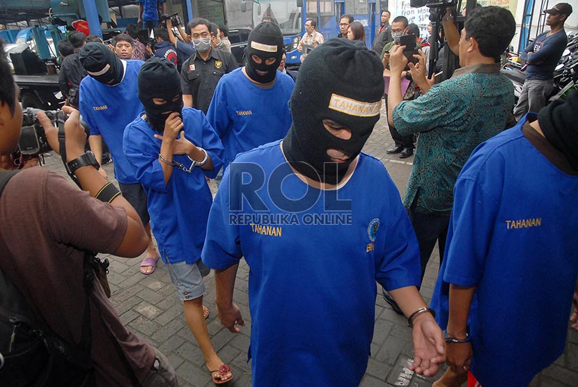 Tersangka didampingi petugas usai memusnahkan barang bukti pada rilis peredaran gelap narkoba di halaman gedung BNN, Jakarta Timur, Selasa (18/2)