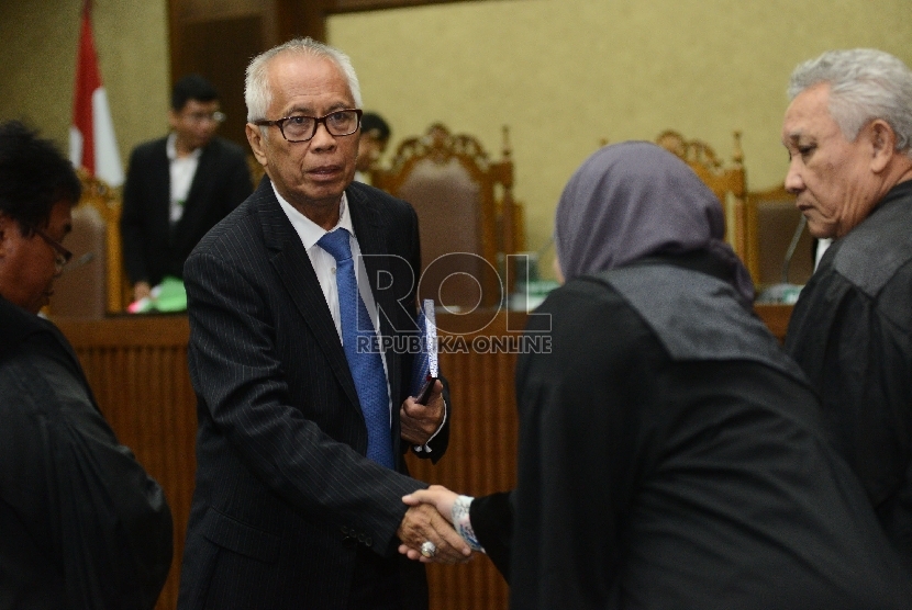 Tersangka dugaan suap kepada Hakim dan Panitera PTUN Medan, OC Kaligis berjabat tangan dengan penasehat hukumnya usai menjalani Sidang dengan agenda pembacaan vonis di Pengadilan Tipikor, Jakarta, Kamis (17/12).