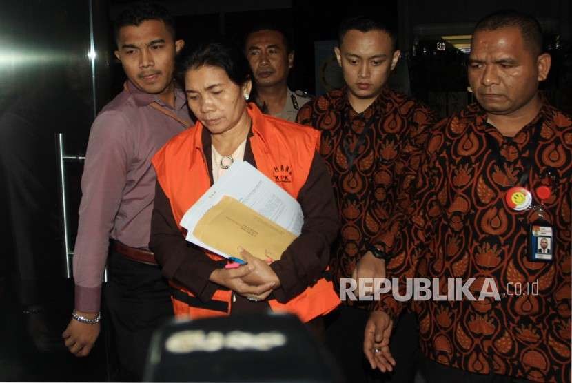 Tersangka Hakim Adhoc Tipikor Pengadilan Negeri Medan, Merry Purba (tengah), mengenakan rompi tahanan saat berjalan menuju mobil tahanan usai diperiksa di gedung KPK, Jakarta, Rabu (29/8).