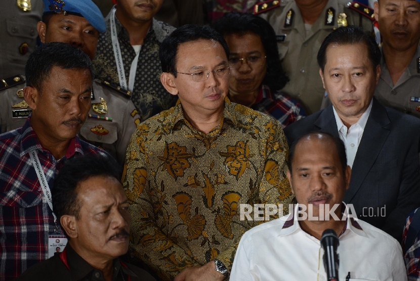 Tersangka kasus penistaan agama yang juga Calon Gubernur DKI Jakarta Basuki Tjahaja Purnama (tengah) keluar dari ruangan seusai menjalani pemeriksaan di Mabes Polri, Jakarta, Selasa (22/11). 