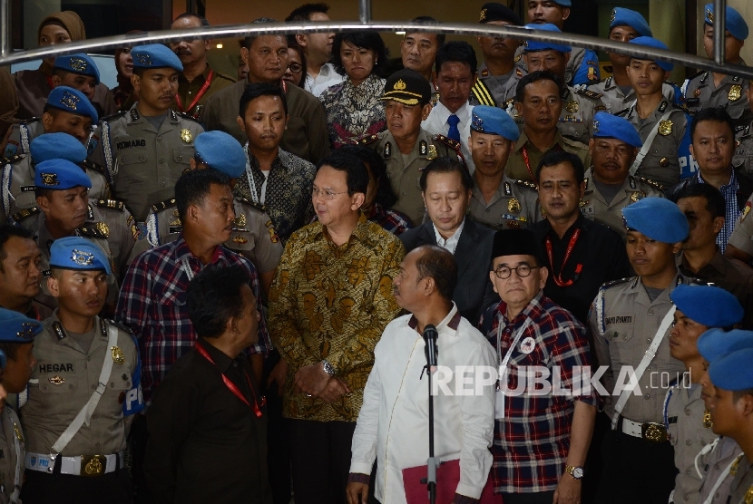 Tersangka kasus penistaan agama yang juga Calon Gubernur DKI Jakarta Basuki Tjahaja Purnama (kedua kiri) keluar dari ruangan seusai menjalani pemeriksaan di Mabes Polri, Jakarta, Selasa (22/11). 