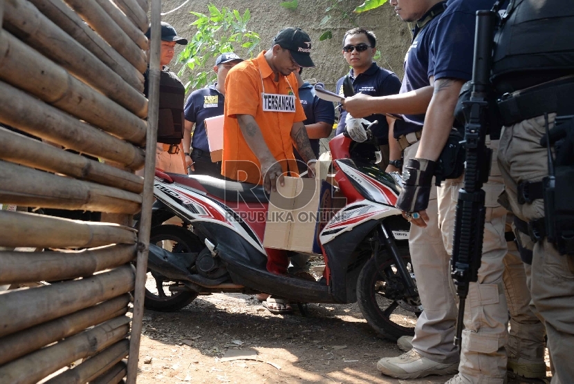 Tersangka kasus pencabulan dan pembunuhan bocah dalam kardus, AD, memperagakan adegan saat rekonstruksi kasus pembunuhan bocah dalam kardus di Kalideres, Jakarta Barat, Selasa (20/10). (Republika/Yasin Habibi)