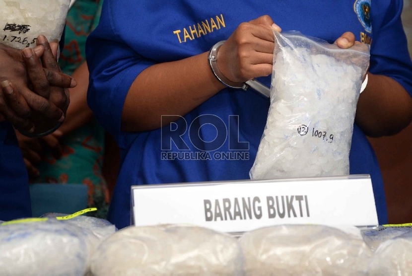 Tersangka pengedar sabu menunjukan barang bukti sabu saat rilis narkotika di gedung BNN, Jakarta, Jum'at (12/6).(Republika/Yasin Habibi)