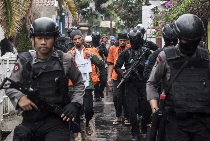 Tersangka teroris SH (kanan) dan AR (kiri) dikawal ketat petugas Densus 88 Antiteror saat rekonstruksi rencana pembuatan bom di Kiaracondong, Bandung, Jawa Barat, beberapa waktu lalu.