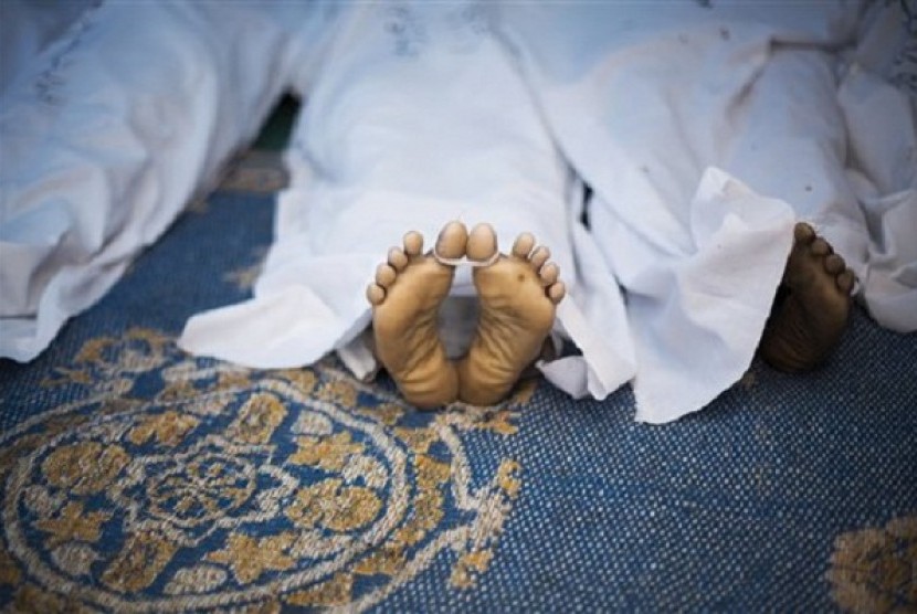 The corpse of a supporter for Egypt's ousted President Mohammed Morsi, killed during clashes with security forces at Nasr City, where pro-Morsi protesters have held a weeks-long sit-in, lies down on the floor of a field hospital in Cairo, Egypt, Saturday, 