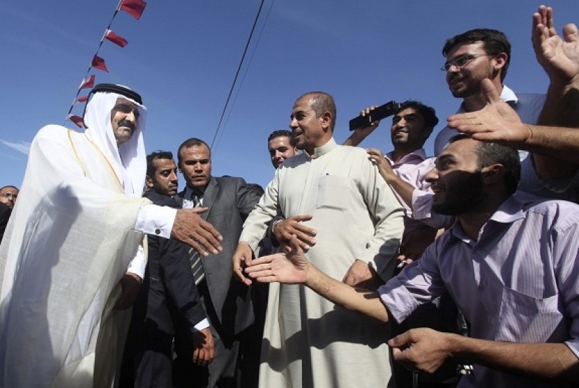 The Emir of Qatar Sheikh Hamad bin Khalifa al-Thani (left) is greeted by Palestinians upon his arrival to a cornerstone laying ceremony for a new center providing artificial limbs, in Beit Lahiya in the northern Gaza Strip October 23, 2012.   