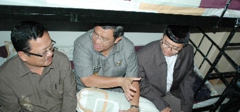 The Governor of West Java, Ahmad Heriyawan (center) sits on the bed in Yatim Apartment, recently.  
