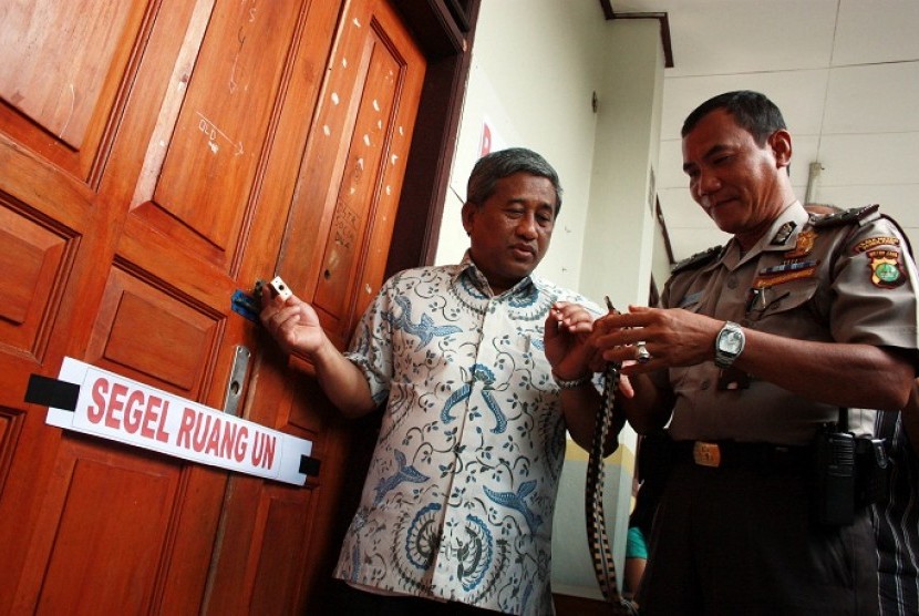 The Minister of Education and Culture, Mohammad Nuh (left), inspects the padlock of the room used to store the examination materials on Saturday.   