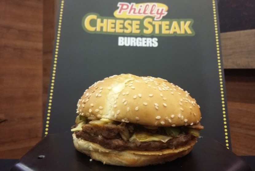 The Philly Cheesesteak Burger berisi potongan tipis daging steak di atas daging burger, lalu dilengkapi dengan paprika, bawang bombay, keju, dan mayones.