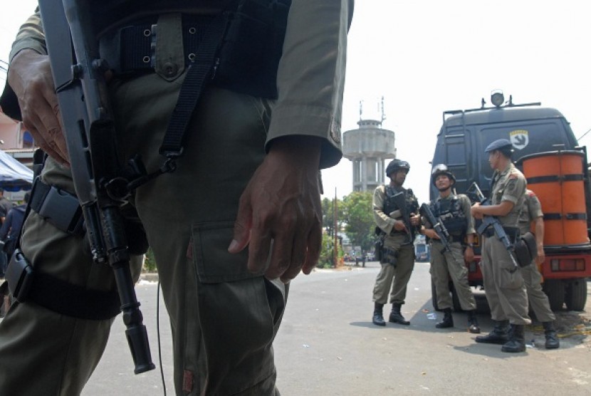 The police take guard while the bomb squad examine the bombing scene in Depok, outskirt of Jakarta, Sunday. 