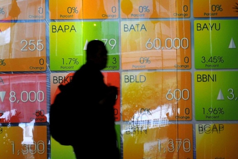  A man passes screen of stock prices at IDX. (illustration)