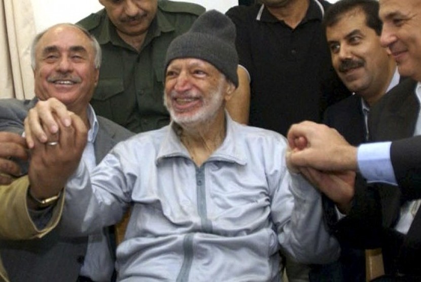 Then Palestinian President Yasser Arafat sits (center) surrounded by doctors from Tunis, Egypt and Jordan in his office in the West Bank City of Ramallah in this October 28, 2004 (file photo).   