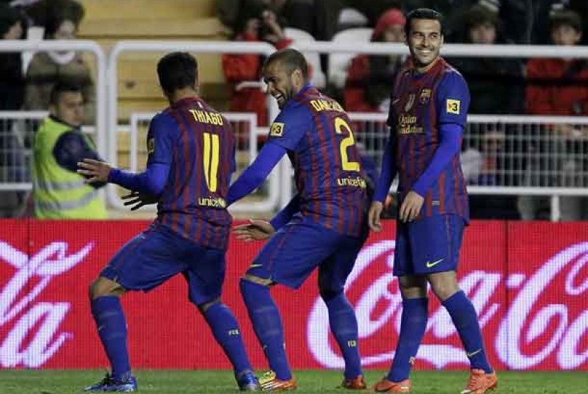 Thiago Alcantara, kiri, merayakan golnya bersama Daniel Alves dan Pedro Rodrigues saat tim mereka Barcelona bertanding melawan Rayo Vallecano di Teresa Rivera, Madrid, Spanyol, Senin (30/4) dinihari WIB. Barca menang telak 7-0.