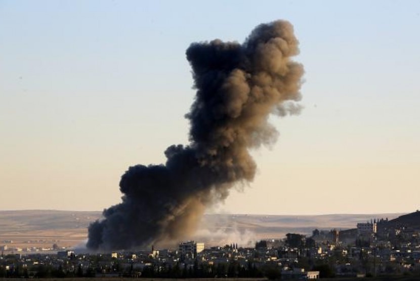 Thick black smoke rises over an eastern Kobani neighborhood following an air strike on November 8, 2014.