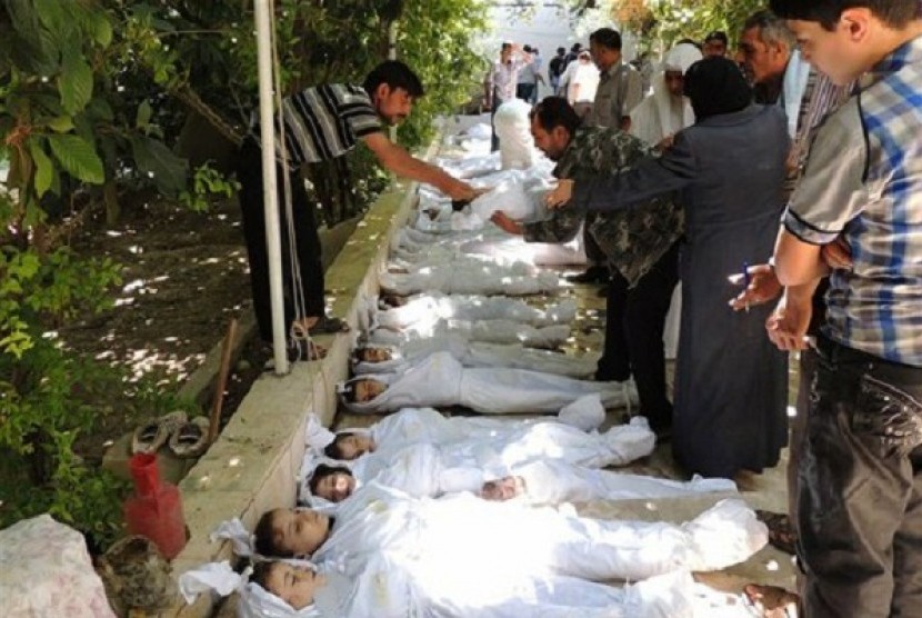 Syrian citizens try to identify dead bodies, after an alleged poisonous gas attack fired by regime forces, according to activists in Arbeen town, Damascus, Syria, Wednesday, Aug. 21, 2013. 