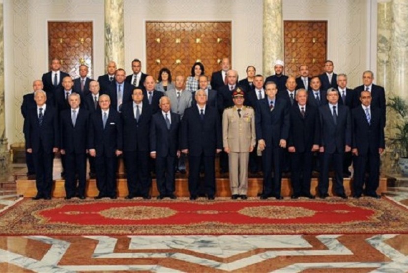 This image released by the Egyptian Presidency on Tuesday, July 16, 2013 shows interim President Adly Mansour, center, with his new cabinet ministers at the presidential palace in Cairo, Egypt. 