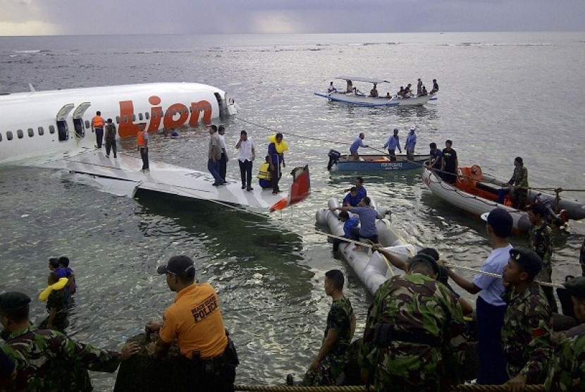 This photo released by Indonesia's National Rescue Team shows rescuers at the crash site of a Lion Air plane in Bali, Indonesia on Saturday, April 13, 2013.
