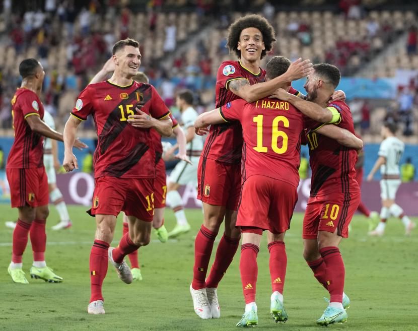 Thorgan Hazard (tengah) dari Belgia merayakan dengan rekan setimnya setelah mencetak gol pembuka pada pertandingan sepak bola babak 16 besar UEFA EURO 2020 antara Belgia dan Portugal di Seville, Spanyol, 27 Juni 2021. 