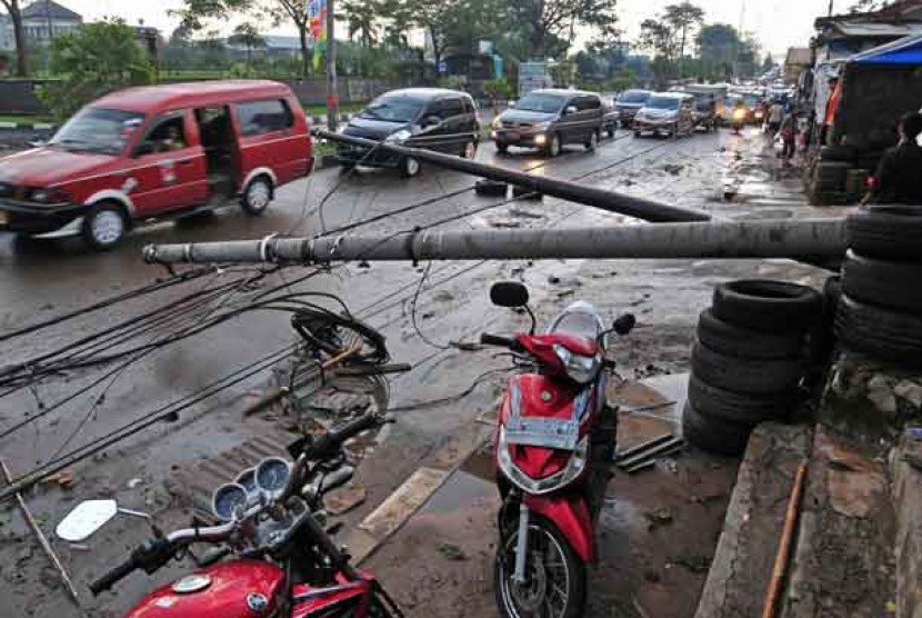  Tiang listrik tumbang di jalan Cut Meutia, Bekasi Timur, Bekasi,Sabtu (8/6), akibat angin kencang yang melanda kawasan tersebut.