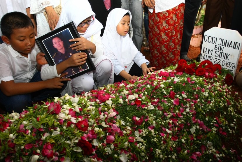 Tiga anak almarhum Dodi Junaidi (40), Zia (kiri), Mutia (tengah) dan Putri (kanan) berdoa di pusara ayahnya seusai dimakamkan di Rempoa, Tangerang Selatan, Banten, Senin (5/11/2018).