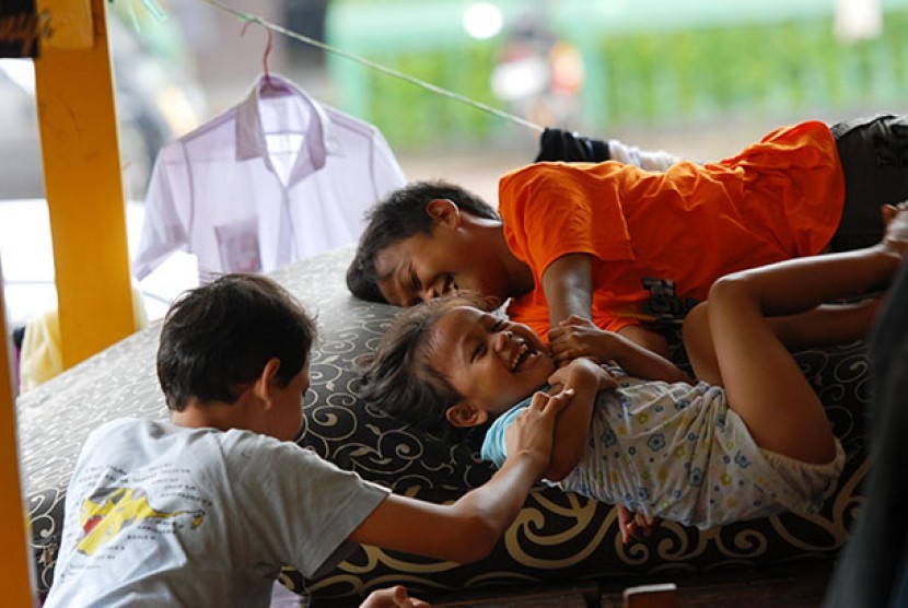 Tiga anak yang mengungsi akibat banjir di Pengadegan,Jakarta Selatan.