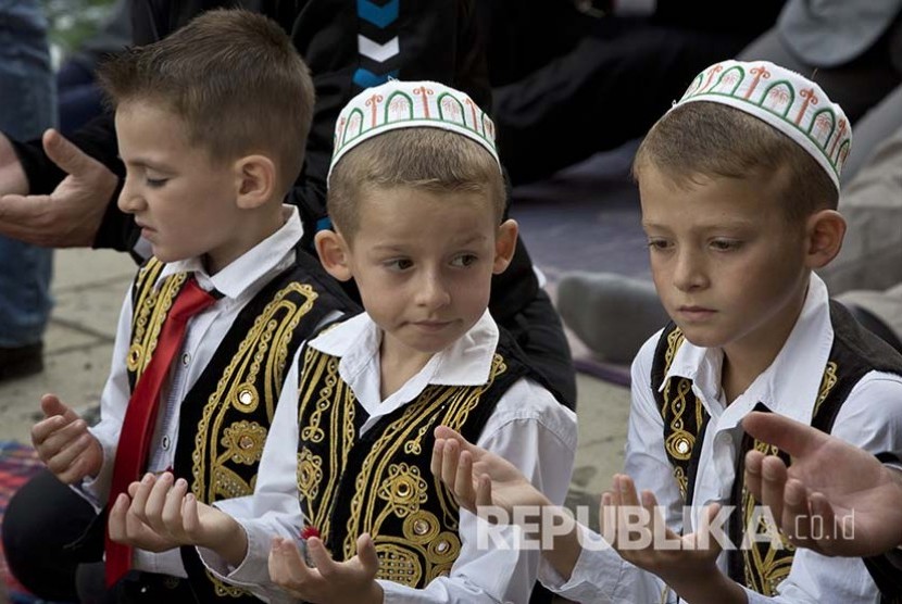 Tiga bocah Kosovo berdoa saat shalat Ied di ibukota Kosovo, Pristina, Senin (12/9) 