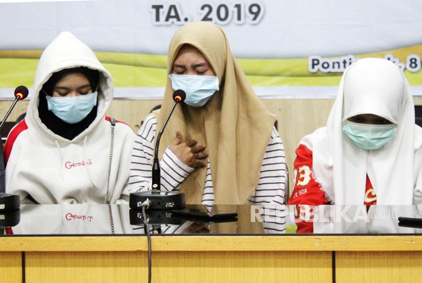 Tiga dari 12 siswi SMU yang diduga menjadi pelaku dan saksi dalam kasus penganiayaan siswi SMP berinisial AU (14) memberi keterangan saat jumpa pers di Mapolresta Pontianak, Kalimantan Barat, Rabu (10/4/2019). 