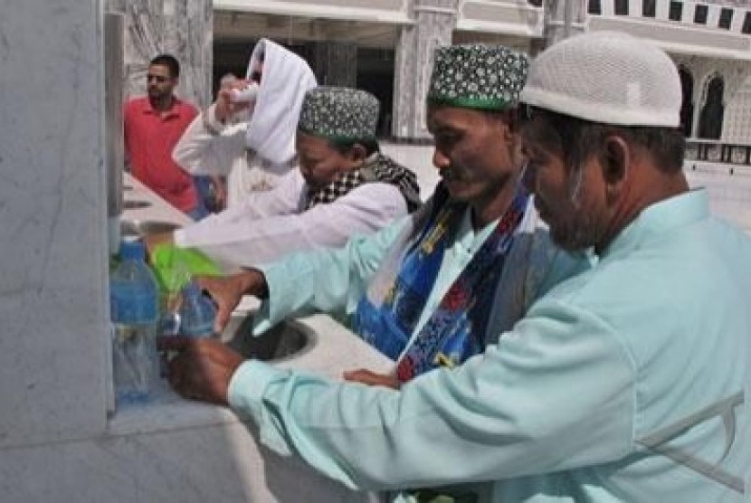 Tiga jamaah haji Indonesia asal Sidoharjo, Jatim, memasukan air zamzam ke dalam botol