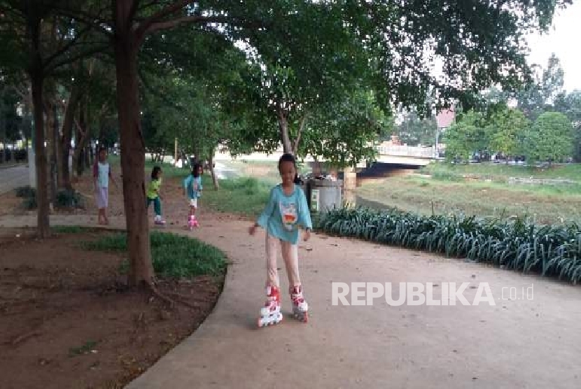 Tiga orang anak bermain sepatu roda di taman BKT Duren Sawit Jakarta, Selasa (25/4).