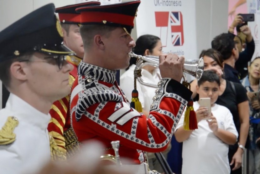 Tiga orang angota militer Kerajaan Inggris yang berseragam lengkap memberikan sajian musik marching band di Statiun MRT Dukuh Atas, Jakarta.