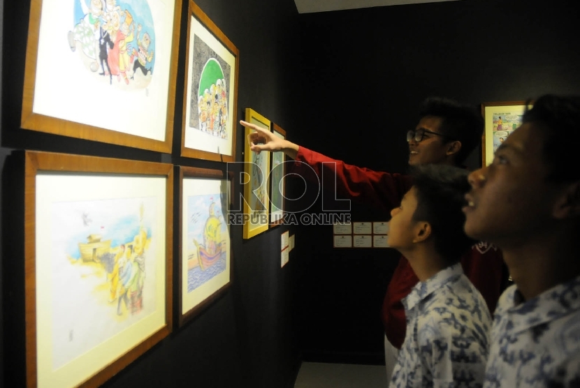   Tiga orang Pelajar SMP memperhatikan karya kartun, pada pameran Kartun Santri Nusantara di Galeri Nasional Jakarta, Kamis (26/11).