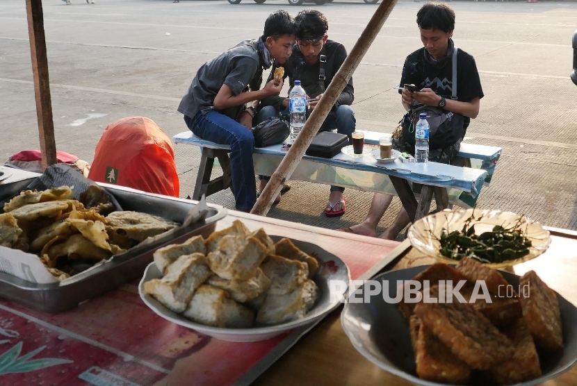 Tiga orang pemudik nampak melepas lelah di warung kopi di terminal bus Pulogadung Jakarta, Senin (11/7). (Republika/Darmawan)