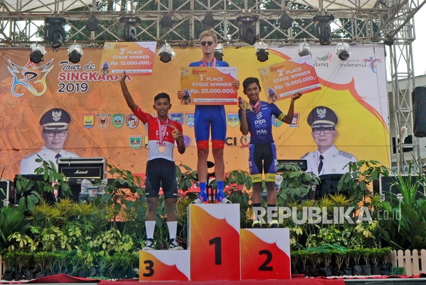 Tiga pebalap Jesse Ewart (tengah), Firdaus Ahmad Yoga Ilham (kanan) dan Jamalidin Novardianto, menerima penghargaan etape kedua Tour de Singkarak (TDS) 2019, di Kawasan Jam Gadang, Bukitinggi, Sumatera Barat, Ahad (3/11/2019). 