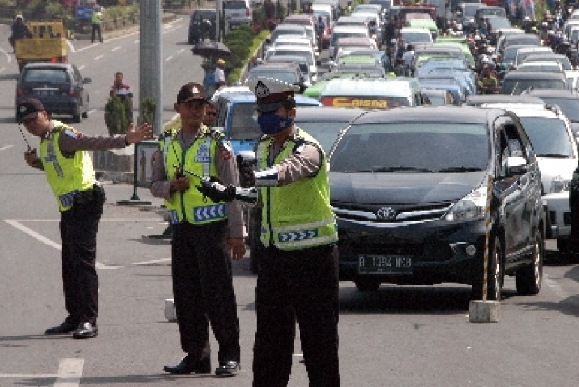 Tiga Polisi mengatur lalu lintas menuju kawasan wisata Puncak di Gadog, Ciawi, Bogor, Jabar.