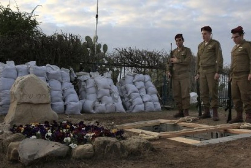  Tiga tentara berdiri di pinggir makam Ariel Sharon dalam prosesi penguburan mantan perdana menteri Israel itu di samping makam Istrinya, di Gunung Negev, dekat perbatasan Gaza pada Senin (13/1/2014)