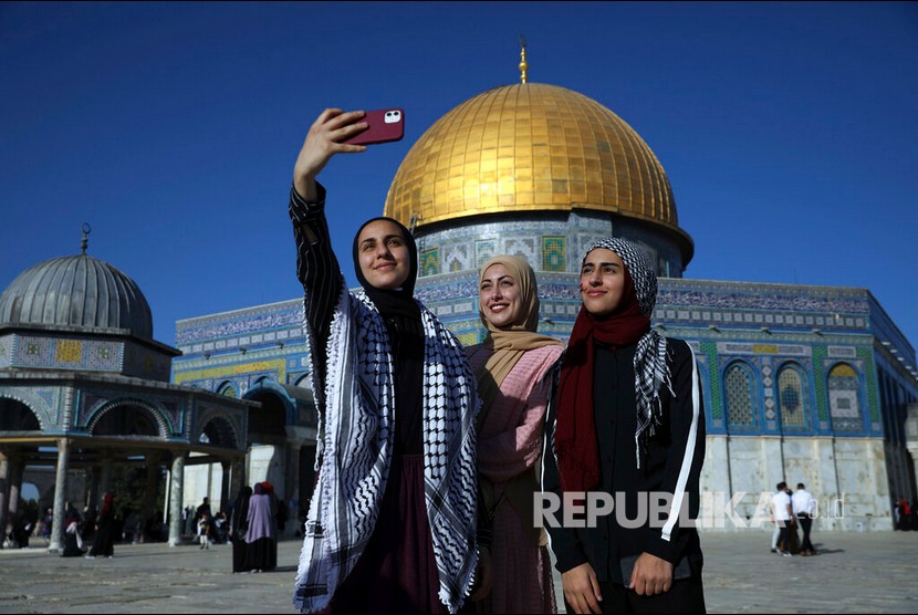  Tiga wanita Palestina berpose dengan latar Masjid Kubah Batu usai melaksanakan sholat Idul Fitri di Komplek Masjid Al Aqsa, Yerusalem. Lebih dari 200 ribu jamaah sholat Idul Fitri dengan damai di kompleks Masjid Al-Aqsa. Ilustrasi. 