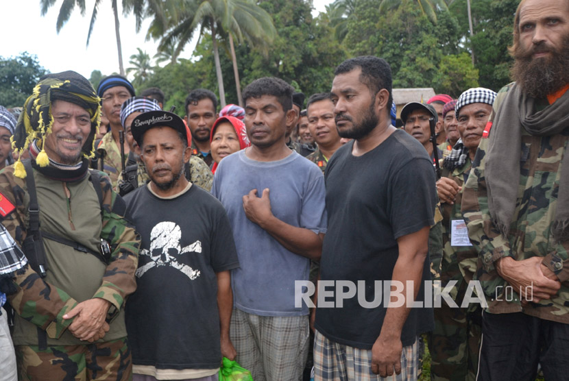 Tiga warga negara Indonesia dan Norwegia  berdiri di samping Pemimpin Front Pembebasan Nasional Moro (MNLF)  Nur Misuari  setelah para sandera dibebaskan dari kelompok militan Abu Sayyaf , di Jolo , Sulu di Filipina.