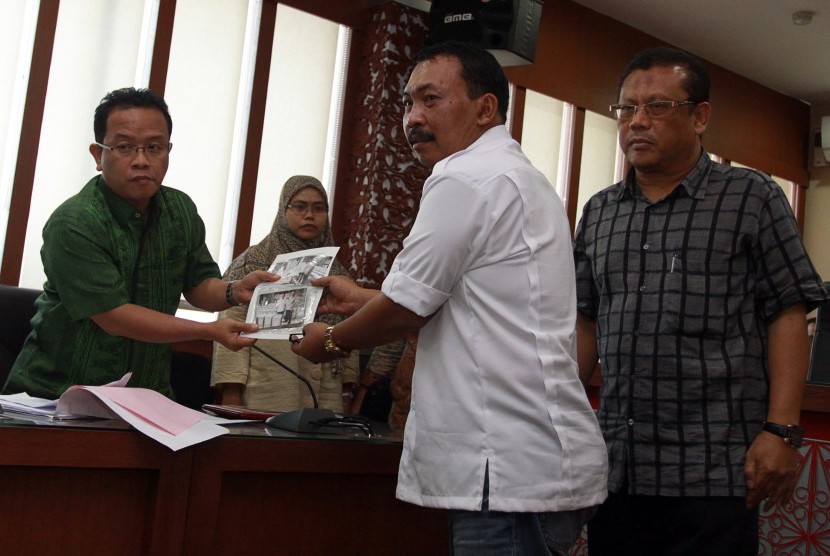Tim Advokat Prabowo-Hatta beserta anggotanya menyerahkan barang bukti kecurangan pada Pilpres 2014 kepada anggota DKPP Nur Hidayat Sardini (kiri) saat melaporkan Komisi Pemilihan Umum (KPU) dan Badan Pengawas Pemilu (Bawaslu) ke kantor DKPP, Jakarta, Kamis