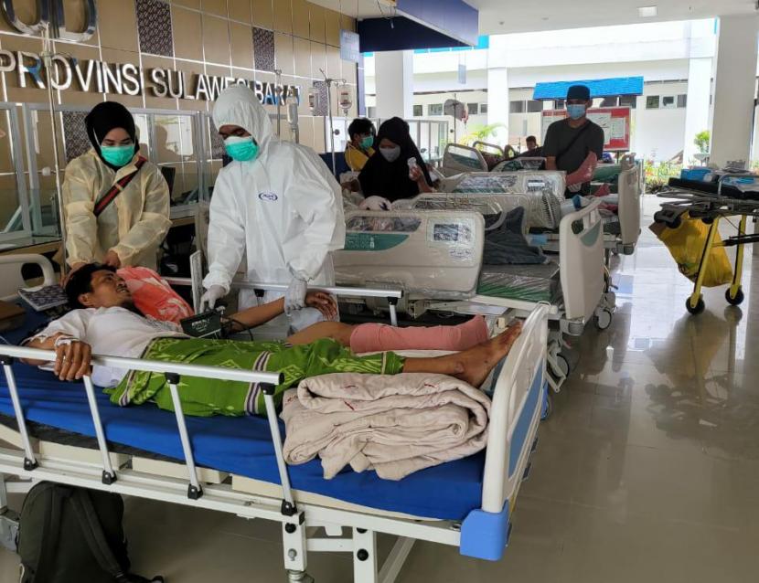 Pasien pascaoperasi terpaksa dirawat di lorong-lorong rumah sakit. Tim bantuan medis dari Universitas Hasanuddin, Makassar dipimpin oleh mantan Rektor Unhas Prof Dr dr Idrus Paturuwmsi, memberikan penanganan medis seperti operasi patah tulang terhadap korban bencana di Mamuju Sulawesi Barat, Ahad (17/1). 