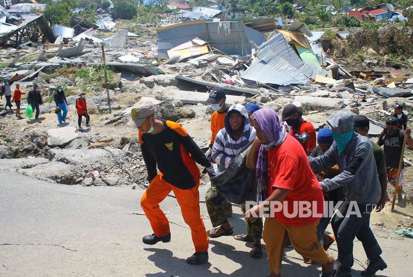 Tim Basarnas dibantu warga mengangkat jenazah saat evakuasi pascagempa di Kompleks Perumahan Nasional Kelurahan Bala Roa, Kota Palu, Sulawesi Tengah, Selasa (2/10). 