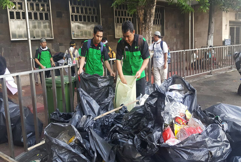  Tim BIS Dompet Dhuafa dan AQL Islamic Center, tengah membersihkan sampah di Pintu Al-Fattah Masjid Istiqlal, Jumat (4/11). 