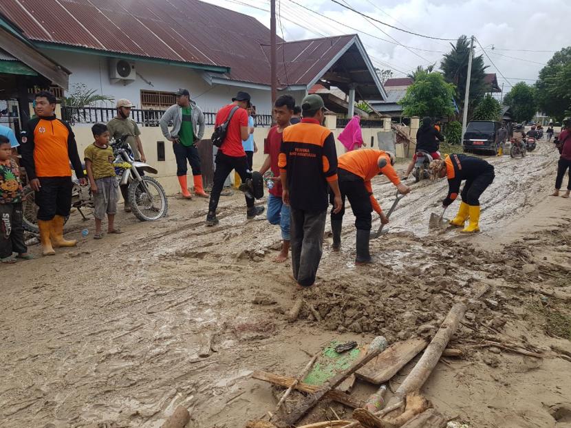 Tim BMH bersama SAR Hidayatullah membersihkan material lumpur sisa banjir di Masamba, Luwu Utara.