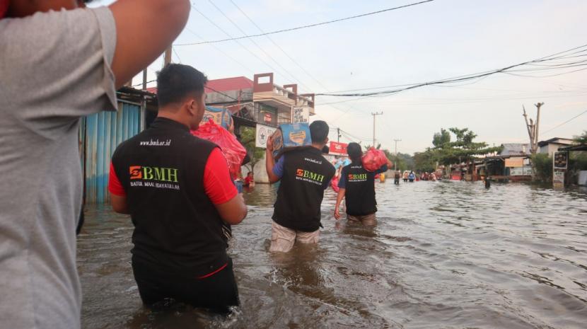 Tim BMH melintasi banjir untuk mengantarkan bantuan bagi korban banjir di Samarinda.