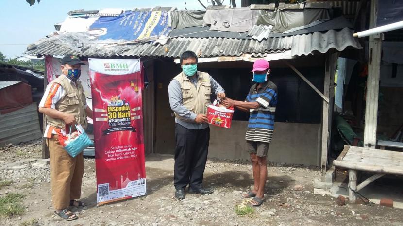 Tim BMH menyisir dari rumah ke rumah untuk mengantarkan paket sembako kepada warga yang tinggal di bantaran sungai Singkil Sidoarjo.