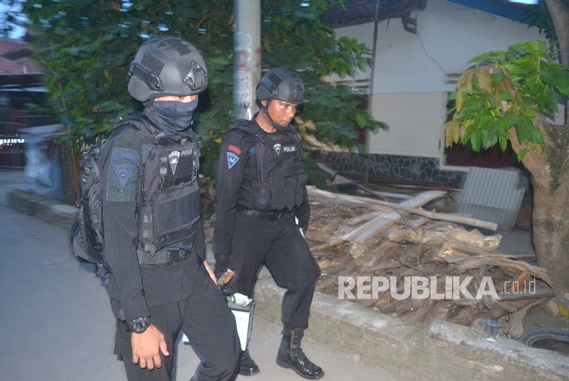 Tim Densus 88 membawa barang bukti saat penggeledahan usai penangkapan terduga teroris di Jemaras, Klangenan, Kab. Cirebon, Jawa Barat, Kamis (17/5).