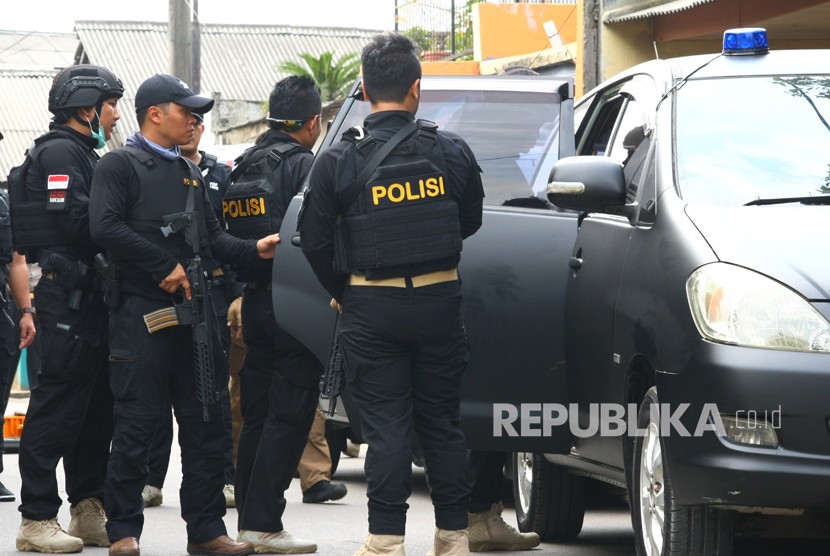 Tim Densus 88 mengamankan istri terduga Teroris saat dilakukan penggerebekan di Gempol, Tangerang, Banten, Rabu (16/5).