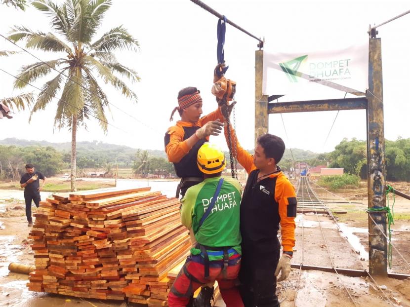 Tim Disaster Management Center (DMC) Dompet Dhuafa sedang membangun jembatan gantung sepanjang 120 meter di Desa Calungbungur, Kecamatan Sajira, Kabupaten Lebak, Provinsi Banten, Rabu (11/3).(Republika/Fuji EP)