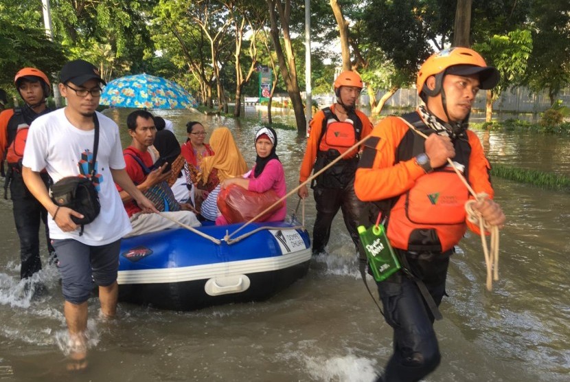 Tim DMC Dompet Dhuafa mengevakuasi warga terdampak banjir.