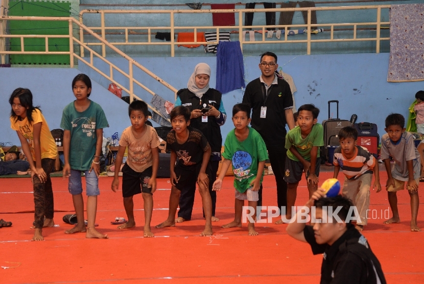  Tim Dukungan Psikososial Kemensos bermain dengan anak-anak pengungsi eks-Gafatar di Gedung Pusat Olahraga Persahabatan Korea Indonesia (POPKI), Cibubur, Jakarta Timur, Jumat (29/1).  (Republika/Yasin Habibi)